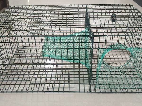The front view of a black lobster trap placed on the ground